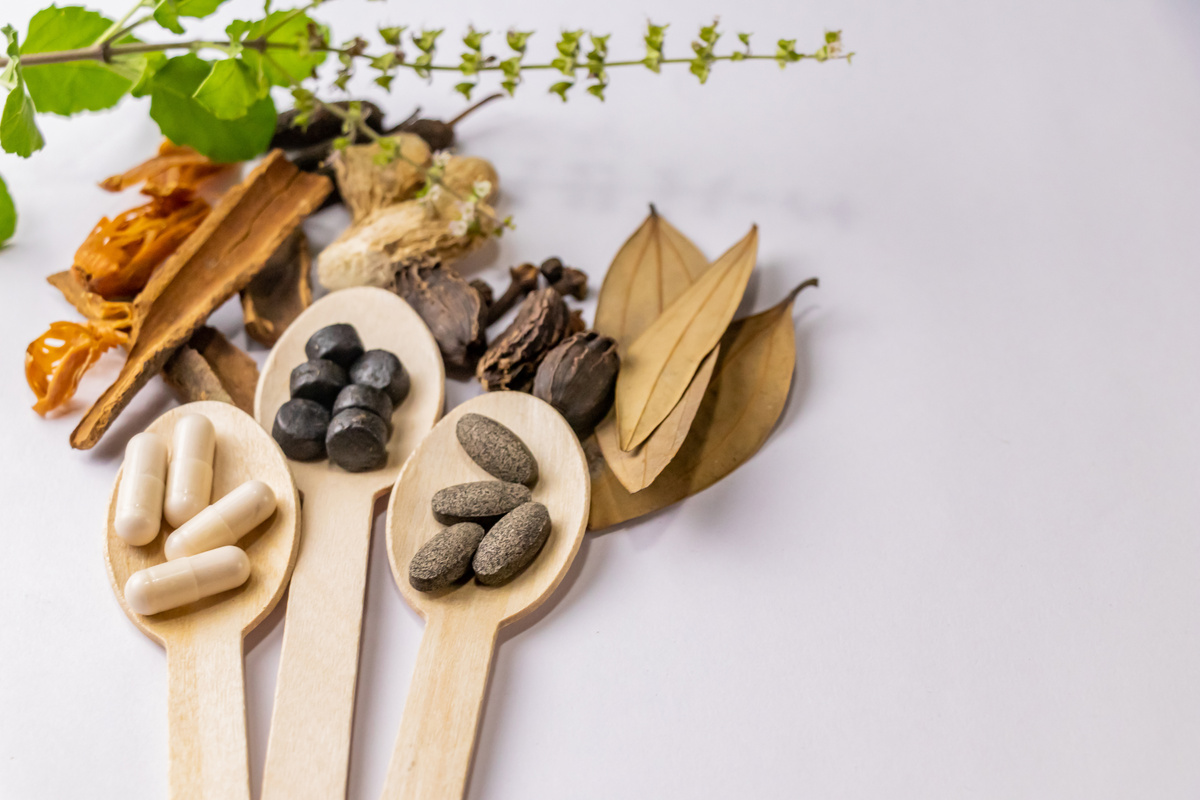 Whole Spices and Ayurvedic Pills in Wooden Spoons